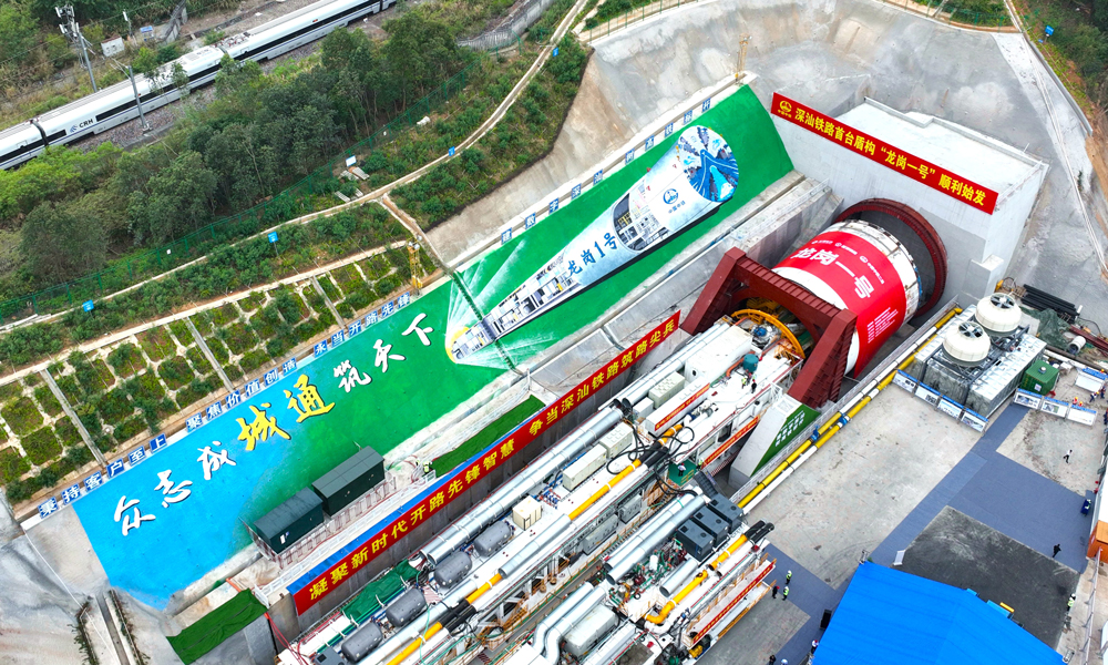 “龍崗一號”盾構機開挖直徑為14.33米，整機全長約122米，總重約3850噸。針對該項目地質特點和施工風險，研發團隊充分發揮大盾構技術優勢，結合工程實際和豐富施工經驗，從設備結構、排渣方式等方面進行了針對性設計，極大提高了“龍崗一號”盾構機在復雜條件下的適應性，為后續盾構安全高效掘進奠定了堅實基礎。圖為“龍崗一號”盾構機始發現場。