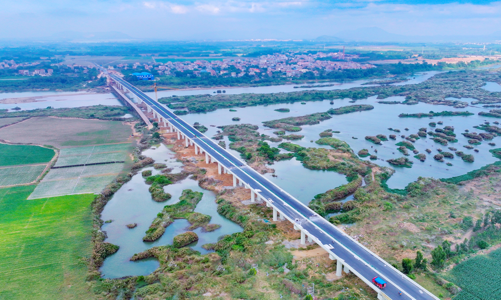 針對旅游公路建設點多線長、作業面廣、影響因素多等困難，項目團隊充分利用“BIM智慧建造+無人機航測技術”，將數字化設計和精細化相結合，縮短了施工工期，提高了施工質量；采用全自動滑模機進行混凝土水溝施工，成品外觀平順，強度、結構尺寸等均滿足設計要求，降低了施工成本，減少了環境污染，實現了智慧建造與綠色工地的高度統一。圖為海南環島旅游公路昌化江大橋。