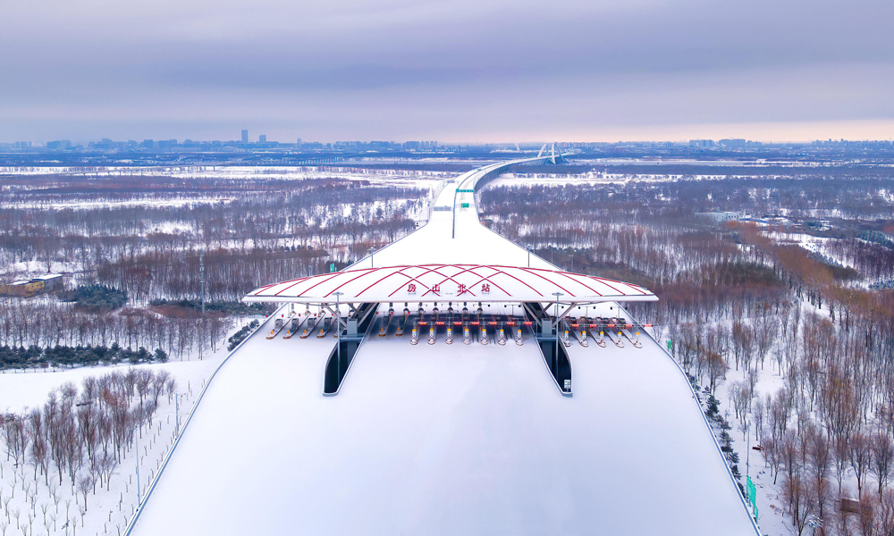 12月28日10時，京雄高速公路（北京段）正式通車運營，并與既有京雄高速河北段相連接，至此京雄高速公路全線順利貫通，從北京西南五環駕車至雄安新區實現了1小時內通達。圖為雪景下的京雄高速公路。