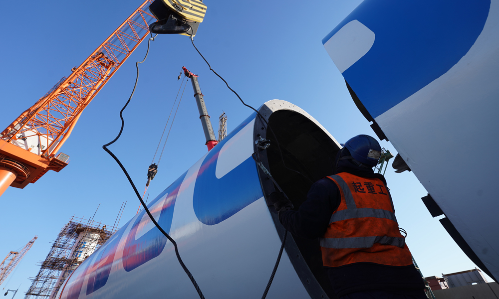 工作人員為船用風力旋筒助推系統塔筒的組裝掛載吊裝鎖具。杜春水 攝