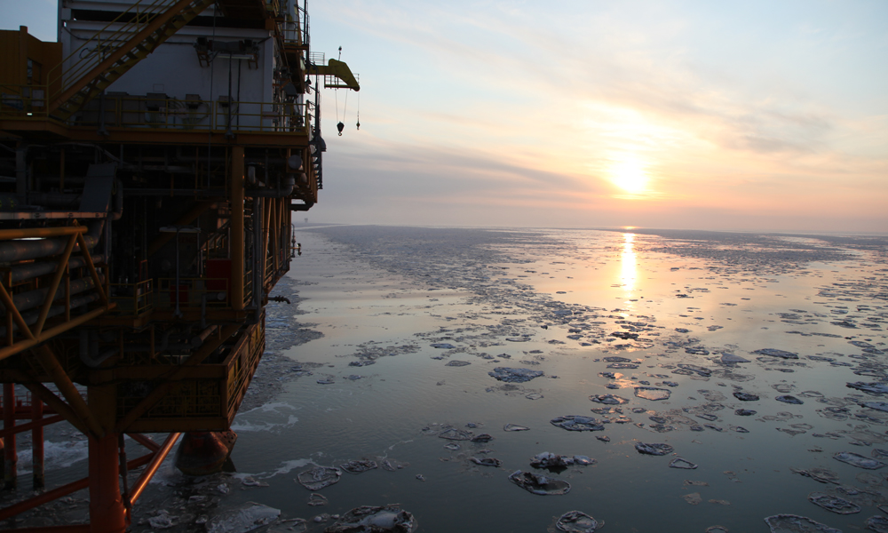 夕陽下的海冰和錦州20-2氣田平臺。