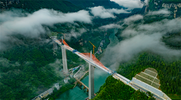 據統計，磨寨烏江特大橋共澆筑混凝土約15萬立方米，安裝鋼筋約2.2萬噸，需要分成37個5到6米的小節段，一節一節多個循環施工。項目建設團隊量身定制了一套超高墩、大截面、重型全封閉智能液壓爬模系統，將各個作業面的位移值、位移差值、液壓系統壓力值以及風速值清晰集成于控制柜的顯示屏上，施工人員可以遠程監控模架運行數據及實時運行情況，通過指尖完成全套操作。在智能化、數字化的系統幫助下，大橋一天可以“長高”1米多，比傳統手動機械系統效率高25%。