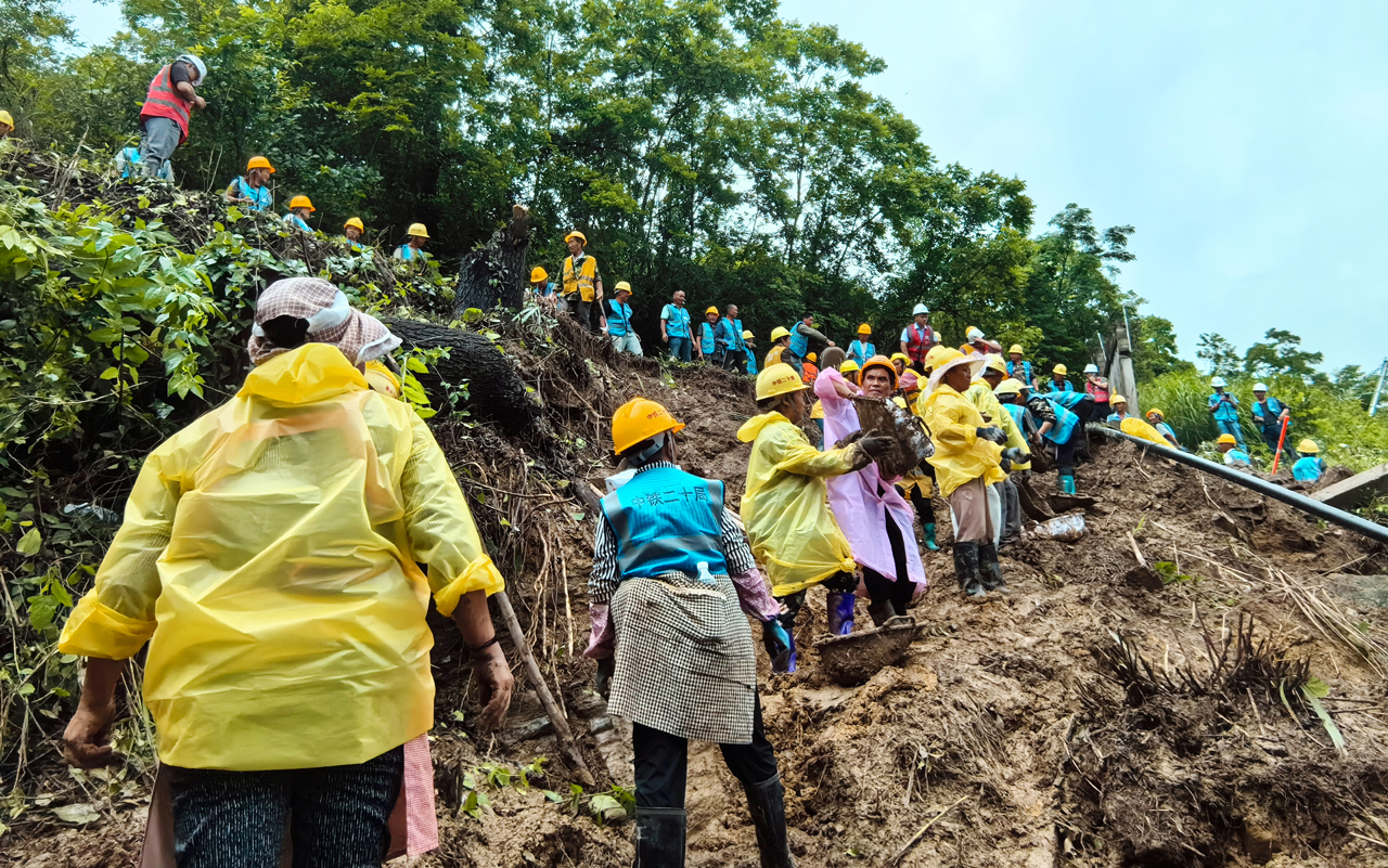 近日，貴州遵義出現今年以來首次特大暴雨。6月17日，播州區三合鎮木瑤堰村的渝貴高鐵（客專）黑石臺隧道右側出現因強降雨引發的險情，將可能造成滑坡、泥石流等次生衍生災害。中鐵二十局貴州公司甕馬鐵路十標項目組織搶險人員和物資、設備火速趕往現場。因搶險現場機械無法抵達，搶險人員肩扛手抬，冒雨展開搶險工作。截至目前，該項目累計投入450余人，運輸車輛70余輛，搶險64個小時，移除260余方坍塌土方，修筑51米臨時截水溝，搭設了32米排架，為鐵路正常通行保駕護航。圖為救援人員正在清理塌方淤泥。