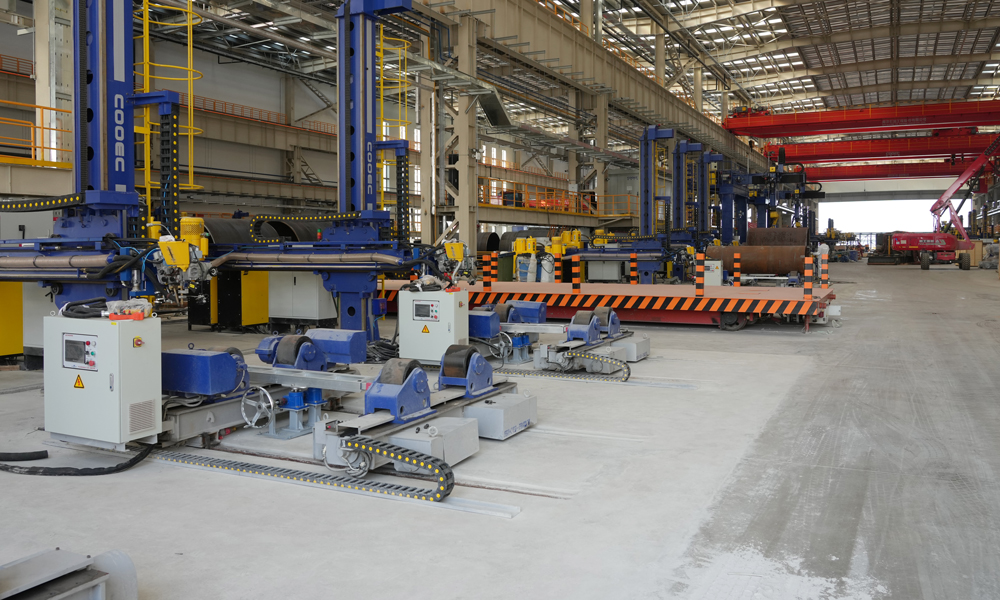 在海油工程天津智能制造基地二期項目的結構管線智造車間，一臺巨大的起重機正進行調試作業，不遠處焊花四濺，工人們正用焊槍進行設備組裝固定。據介紹，該智造車間面積超1.1萬平方米，生產線采用先進的智能技術，可實現智能化決策支持、自動化生產和標準化作業。圖為海油工程臨港智能制造基地二期工程車間。