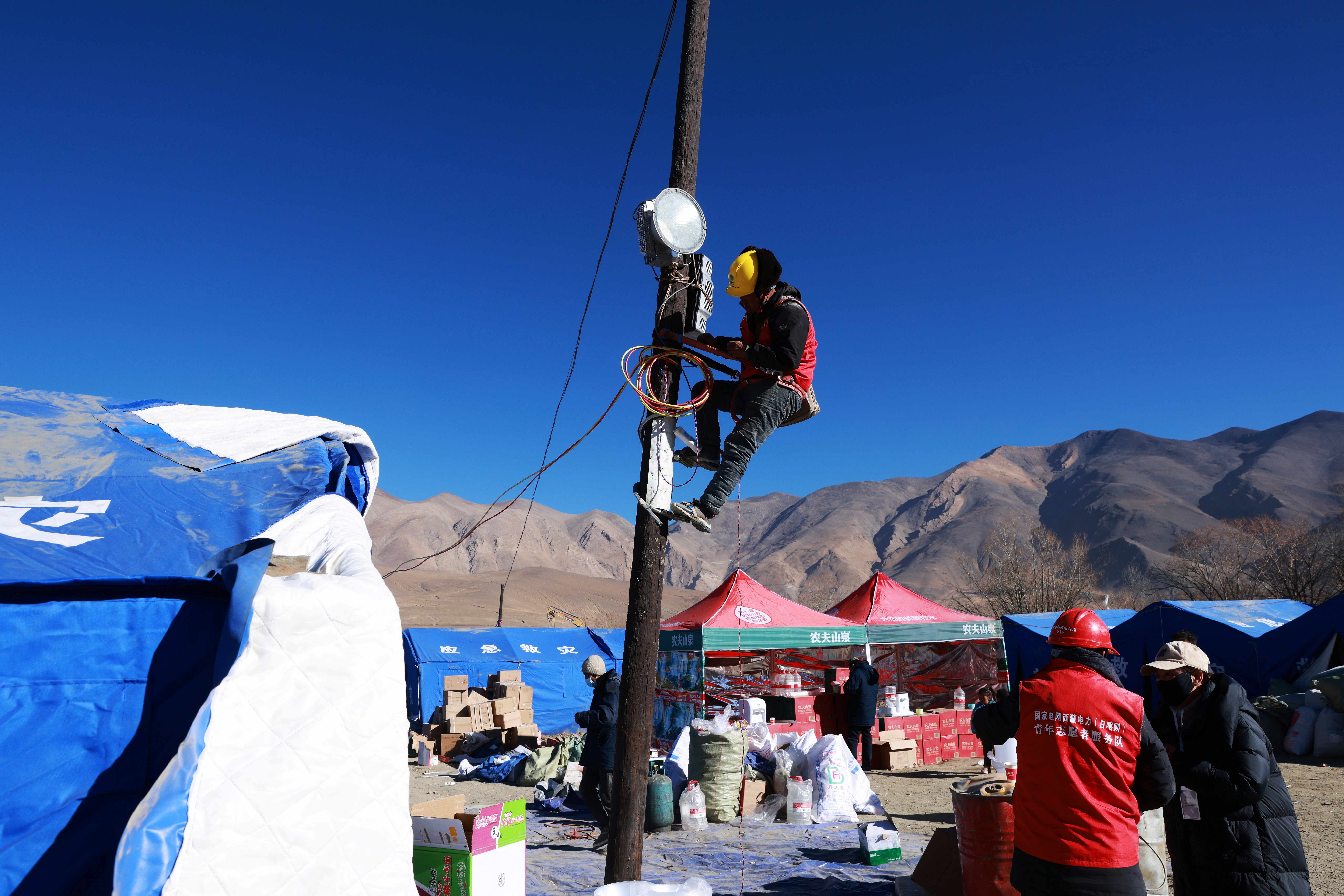 國網西藏電力救災隊伍為定日縣長所鄉通來村居民安置點安裝照明燈。