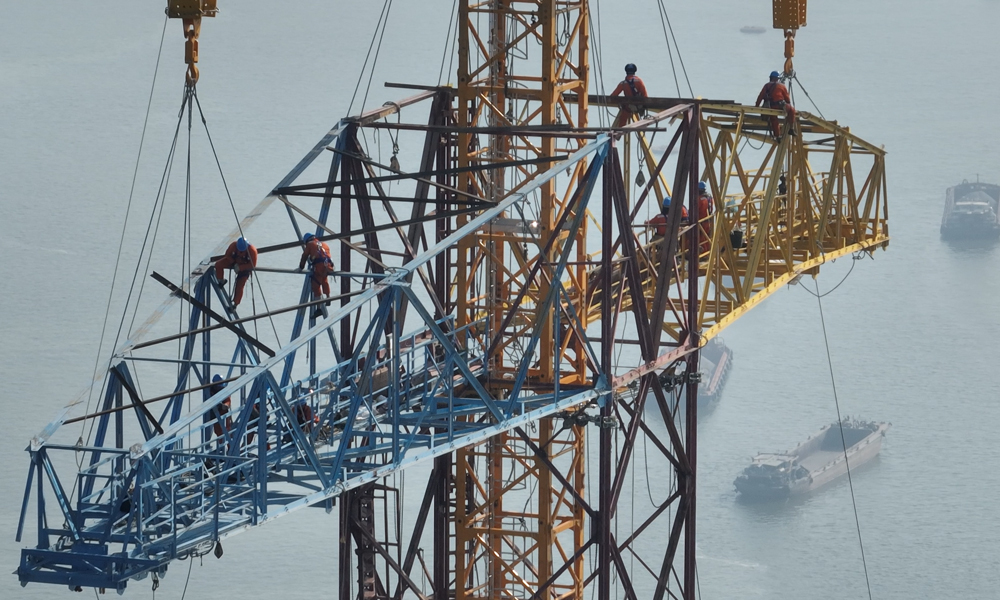 近日，在500千伏沙廣甲乙線改造工程現場，施工人員對跨江鐵塔進行改造施工。