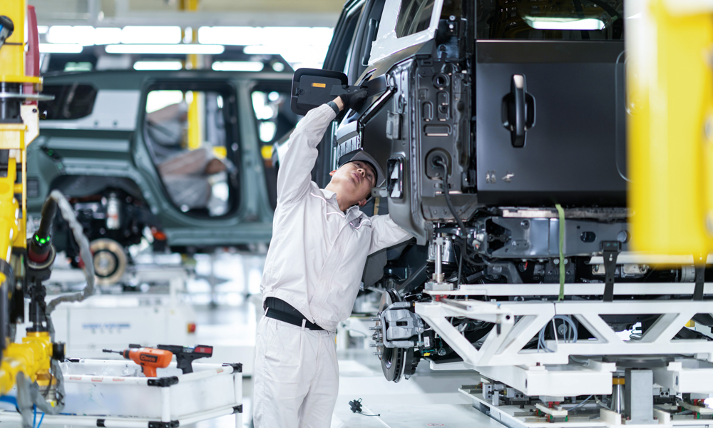 工作人員在位于湖北省武漢市的東風猛士科技工廠開展車架合裝作業。