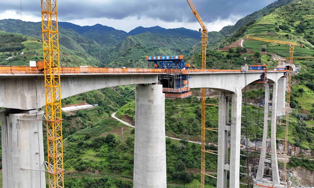 江底牛欄江特大橋橫跨云貴交界處的牛欄江V形河谷地帶，施工場地狹窄，兩岸危巖落石頻發。建設過程中，中鐵二局項目團隊持續改進施工工藝流程等舉措，成功攻克了高空作業墜落風險突出等一系列施工難題，為大橋順利合龍提供了有力支撐。
