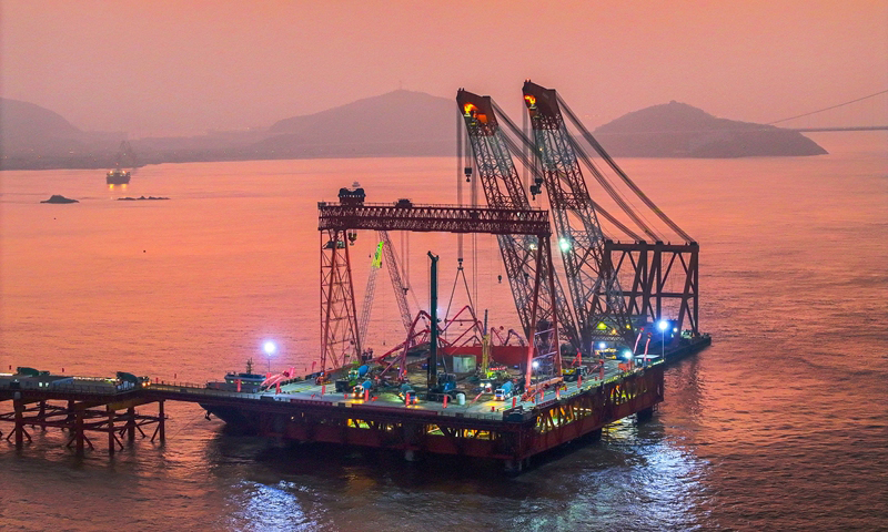 1月7日清晨，甬舟鐵路西堠門公鐵兩用大橋5號主墩超大直徑鉆孔樁灌注施工現(xiàn)場，工人在澆筑最后一根鉆孔樁（無人機照片）。新華社發(fā)（姚峰?攝）