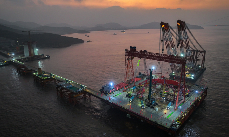 1月7日清晨，甬舟鐵路西堠門公鐵兩用大橋5號主墩超大直徑鉆孔樁灌注施工現(xiàn)場，工人在澆筑最后一根鉆孔樁（無人機照片）。新華社發(fā)（姚峰?攝）