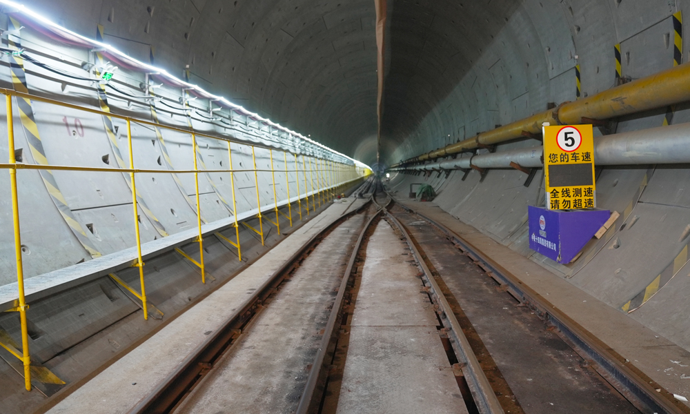 穗莞深城際機(jī)前段工程起于已開通的穗莞深城際深圳機(jī)場站，終至前海站綜合交通樞紐，線路全長約15.2公里，全線地下敷設(shè)，共設(shè)西鄉(xiāng)、寶安、前海3座車站，設(shè)計(jì)時(shí)速160公里。其中下穿海域段長度約3.1公里，采用開挖直徑達(dá)9.14米的泥水平衡盾構(gòu)機(jī)施工，是全線獨(dú)頭掘進(jìn)距離最長、唯一下穿海域的隧道，是全線環(huán)境風(fēng)險(xiǎn)最高的工程。圖為成型后的隧道內(nèi)景。