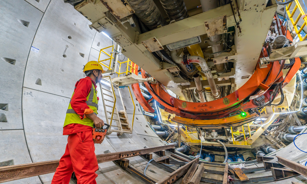 據(jù)了解，項(xiàng)目部克服了長距離、大埋深、高水壓、地質(zhì)復(fù)雜等施工難題。作為國內(nèi)在建城際鐵路最長海底盾構(gòu)隧道，隧道拱頂在海平面以下最大埋深達(dá)62.3米，折算水頭壓力超6巴，相當(dāng)于一個(gè)雞蛋上承載了12斤以上的重物，盾構(gòu)機(jī)在海域下方高水壓環(huán)境中掘進(jìn)，易出現(xiàn)海水貫通風(fēng)險(xiǎn)。同時(shí)盾構(gòu)機(jī)穿越上軟下硬不良地質(zhì)，長距離施工高強(qiáng)度微風(fēng)化花崗巖，巖石最大強(qiáng)度達(dá)105兆帕，長距離在高水壓復(fù)合地層中掘進(jìn)，對盾構(gòu)刀具可靠性要求極高。圖為建設(shè)者正在進(jìn)行管片拼裝作業(yè)。