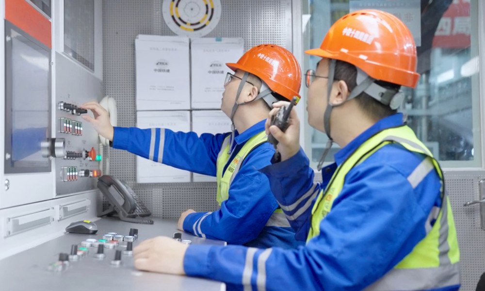 穗莞深城際機(jī)前段工程位于粵港澳大灣區(qū)廣深港城鎮(zhèn)發(fā)展帶與深圳市西部發(fā)展帶內(nèi)，是大灣區(qū)城際鐵路網(wǎng)廣深主軸的重要組成部分，建成通車后將進(jìn)一步提升穗莞深城際鐵路功能，對完善粵港澳大灣區(qū)城際網(wǎng)絡(luò)，實(shí)現(xiàn)區(qū)域經(jīng)濟(jì)一體化發(fā)展具有重要意義。圖為技術(shù)人員在盾構(gòu)機(jī)駕駛室里操作盾構(gòu)機(jī)。