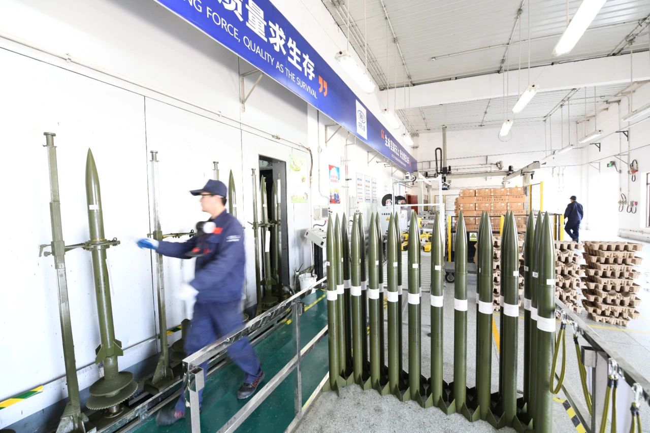 走進航天科技四院中天火箭公司人影火箭科研生產(chǎn)基地，巍峨的遠山與基地內(nèi)規(guī)劃有序的樹木、道路及干凈的藍白色廠房相映成趣。在這家以“服務(wù)氣象 保護生態(tài) 守護綠水青山”為使命的航天企業(yè)，人影火箭均采用環(huán)保材料制造，生產(chǎn)過程綠色無害，回收利用綠色環(huán)保；稱裝藥、噴漆包裝、總裝等重點生產(chǎn)環(huán)節(jié)已實現(xiàn)自動化、信息化，生產(chǎn)方式低碳轉(zhuǎn)型成效顯著。圖為中天火箭公司人影火箭生產(chǎn)現(xiàn)場。