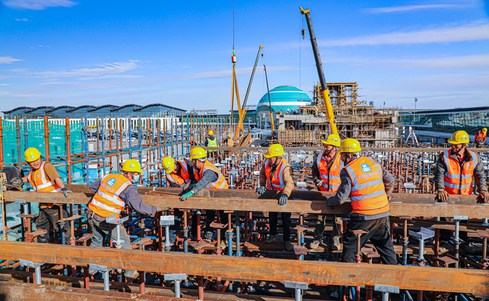 哈薩克斯坦阿斯塔納輕軌項目，是中亞地區(qū)第一條城市輕軌線路，也是中亞地區(qū)第一條全部采用中國標準和中國裝備建造的軌道交通項目。該項目全長約22.4公里，中國建筑旗下中建六局承建了其中的18.34公里，共14個車站、15個區(qū)間及1個車輛段。目前，項目建設正在穩(wěn)步推進中。圖為中方建設者在努爾蘇丹國際機場附近的建設區(qū)間進行現(xiàn)澆梁支架主龍骨安裝作業(yè)。