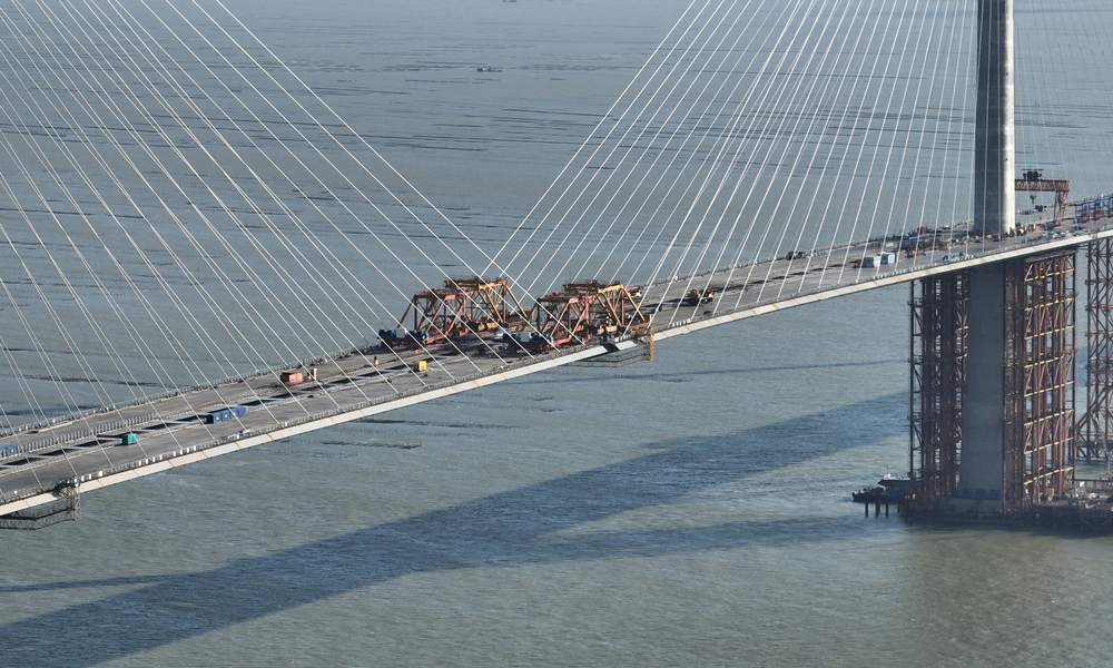 黃茅海大橋跨越黃茅海海域的兩條航道，采用3塔2跨設(shè)計(jì)，是一座獨(dú)柱式雙索面全漂浮體系斜拉橋。大橋單孔跨徑720米，橋梁全長(zhǎng)2200米，共計(jì)16種梁段類型，最重鋼箱梁達(dá)420噸。大橋橋面采用分體式鋼箱梁設(shè)計(jì)，由兩個(gè)鋼箱梁及橫向連接箱組成，橋面總寬50.4米，是分體式鋼箱梁在廣東省內(nèi)首次大規(guī)模應(yīng)用。