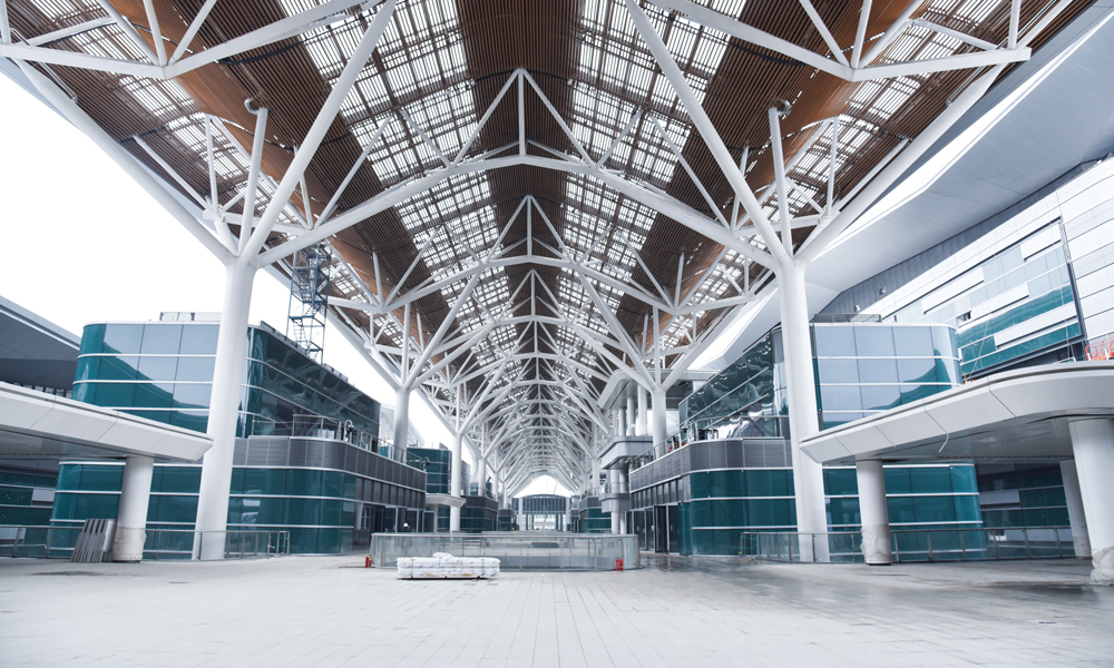 項目屋面采用大面積的“無柱式”施工，總面積為15.5萬平方米，如同22個足球場大，屋面鋼結構總用鋼量12萬噸，規(guī)模國內罕見。項目建設團隊采用大面積整體提升技術，發(fā)明了適用于復雜大跨度鋼屋蓋安裝的高周轉率工具式滑移胎架，研發(fā)了多層大跨鋼結構倒裝法整體提升技術和大跨鋼結構空間豎轉整體安裝技術，將總用鋼量12萬噸，單體跨度最高達81米的屋面桁架穩(wěn)固吊裝，打造錚錚“鋼筋鐵骨”。