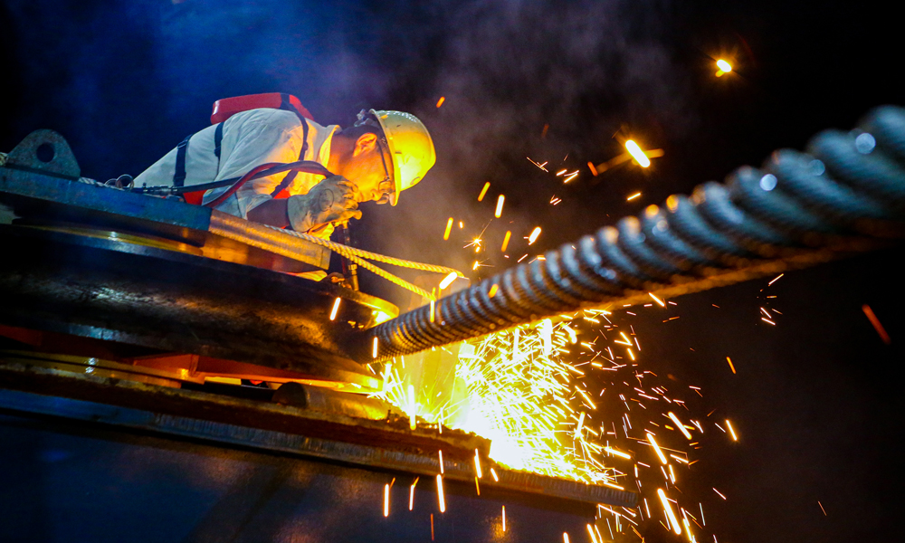 據(jù)海油工程西江30-2項(xiàng)目經(jīng)理介紹，項(xiàng)目組應(yīng)用數(shù)字化工具進(jìn)行三維建模和計(jì)算分析，精心設(shè)計(jì)浮托技術(shù)方案，自主開發(fā)多浮筒懸鏈線計(jì)算軟件，對(duì)系泊布置進(jìn)行反復(fù)優(yōu)化，浮托作業(yè)過程中，通過多拖輪聯(lián)動(dòng)控船，實(shí)現(xiàn)了一次精準(zhǔn)就位。圖為作業(yè)人員在西江30-2B平臺(tái)安裝現(xiàn)場(chǎng)進(jìn)行焊接作業(yè)。