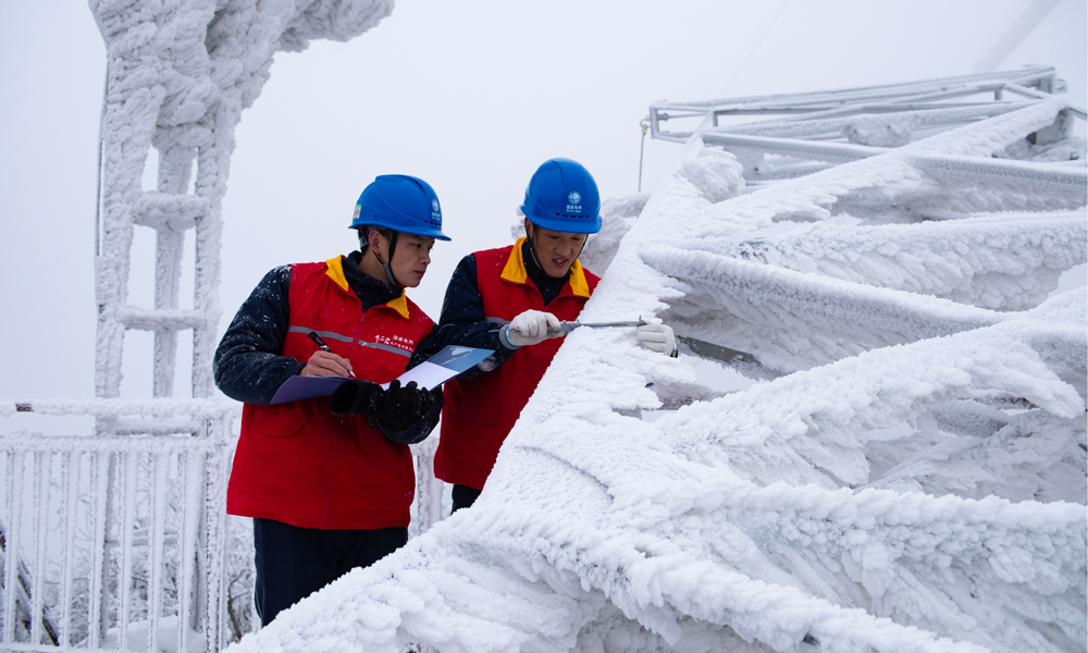 國家電網(wǎng)紅巖（重慶城口）共產(chǎn)黨員服務隊在觀冰點測量220千伏華城線模擬導線覆冰厚度。