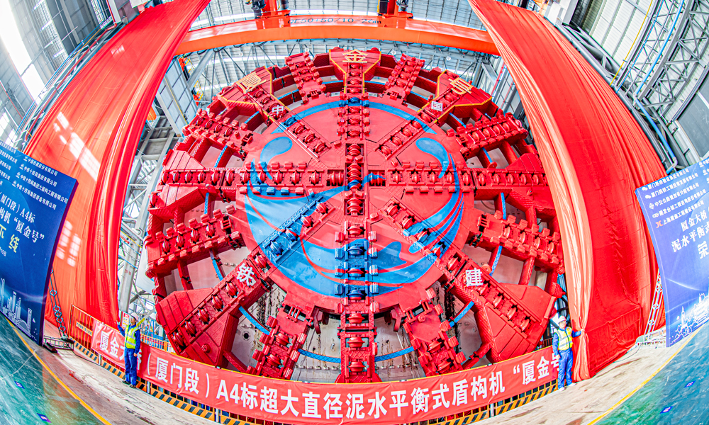 近日，由中國鐵建所屬中鐵十四局參與聯合打造的超大直徑泥水平衡盾構機“廈金號”在江蘇南通下線。該盾構機將應用于廈門至金門大橋（廈門段）主線隧道工程施工。該隧道是福建省在建最大直徑盾構公路隧道。圖為“廈金號” 盾構機下線現場。