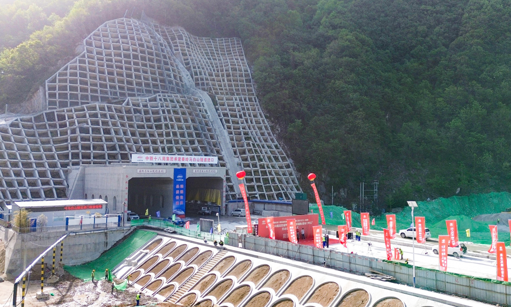 西十高鐵秦嶺馬白山隧道位于陜西省西安市藍(lán)田縣境內(nèi)，全長(zhǎng)22.9公里，為雙洞單線(xiàn)隧道，是西十高鐵全線(xiàn)最長(zhǎng)隧道，也是穿越秦嶺山區(qū)的最長(zhǎng)高鐵隧道。該隧道橫穿秦嶺嶺脊，洞身穿越斷層破碎帶2處，最大埋深超過(guò)620米，地質(zhì)構(gòu)造復(fù)雜多變，具有巖爆風(fēng)險(xiǎn)高、地質(zhì)條件差異大等特點(diǎn)，施工技術(shù)難度和工程風(fēng)險(xiǎn)極高，是全線(xiàn)的關(guān)鍵性控制工程。圖為隧道入口。 