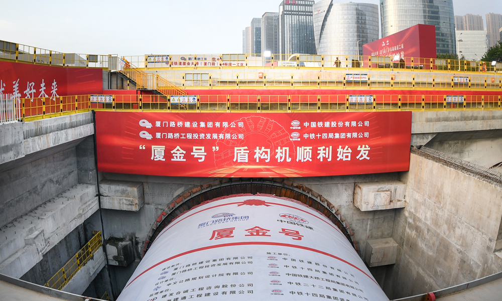 廈金大橋（廈門段）工程起于廈門環(huán)島東路與會展北路交叉口，以隧道形式沿環(huán)島路向北延伸至觀音山，往東以橋梁形式跨越本島東部海域，終點設互通接入廈門翔安國際機場，主線長17.34公里。其中，環(huán)島路隧道長3.29公里，采用盾構(gòu)、明挖法施工，盾構(gòu)隧道左右線分別為1.33公里與1.04公里，為雙向六車道，設計時速80公里，由一臺16米級超大直徑盾構(gòu)機掘進。圖為“廈金號”盾構(gòu)機始發(fā)現(xiàn)場。