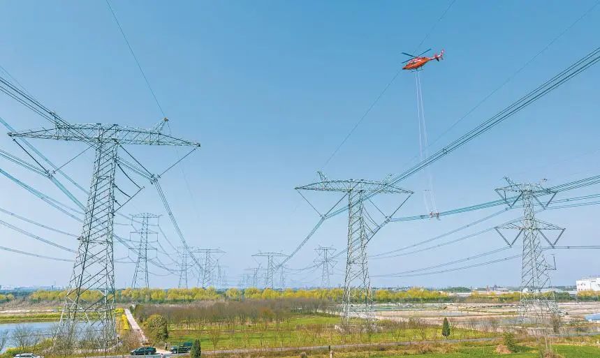 國家電網浙江湖州供電公司聯合國網電力空間技術有限公司對±800千伏特高壓錦蘇線開展直升機帶電檢修。