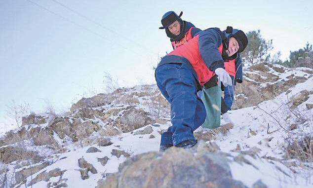 國家電網蒙東通遼奈曼旗供電公司工作人員巡檢10千伏青龍山線后相互攙扶下山。