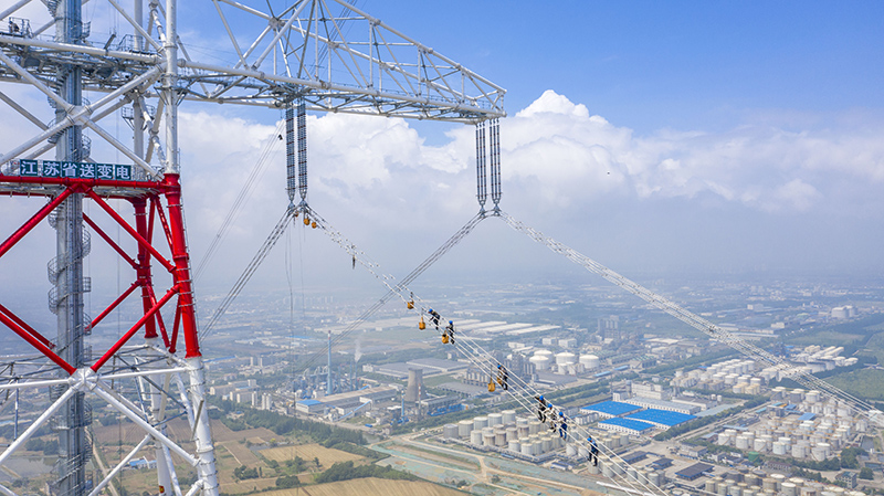 國網江蘇電力員工在鳳城至梅里長江大跨越工程跨江架線上安裝間隔棒。.jpg