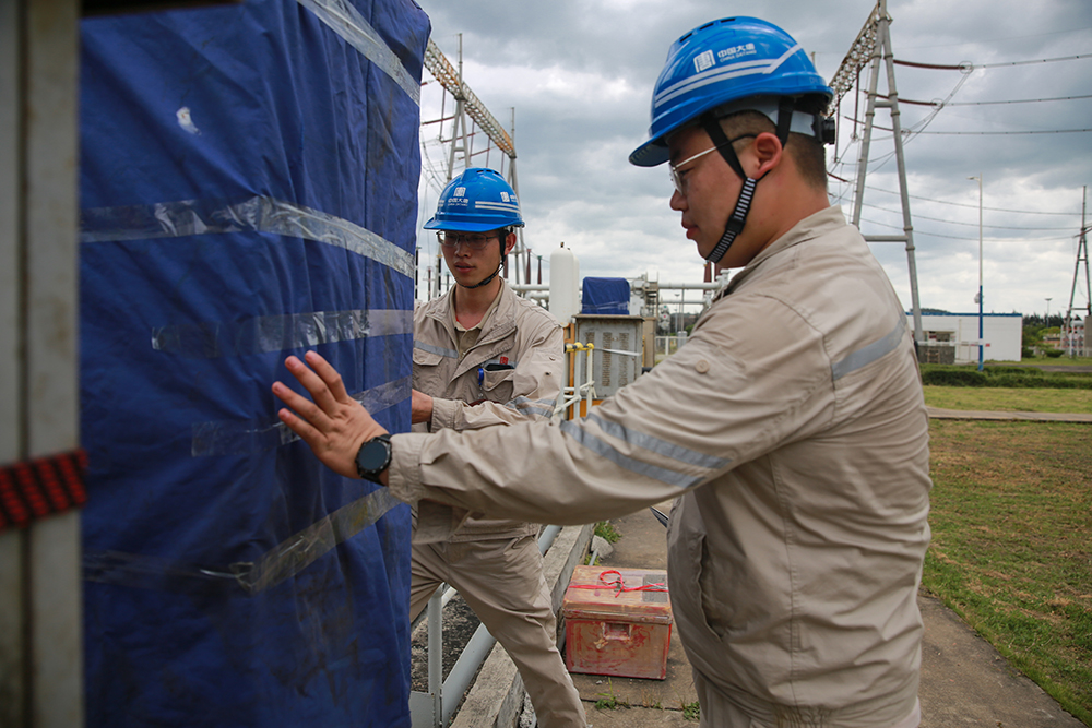 大唐潮州發電公司職工為電氣設備罩設防雨布a.jpg 大唐潮州發電公司職工為電氣設備罩設防雨布a.jpg