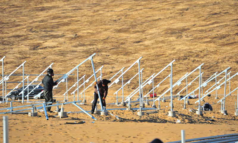 庫布其光伏治沙項目被稱為沙漠中的“太陽谷”，積極應用“治沙+種草+養殖+發電+扶貧”五位一體的復合生態太陽能治沙新模式，項目投產后，社會效益、生態效益、民生效益、經濟效益顯著，可實現治沙面積78000畝。運營周期內可幫扶貧困戶800余戶，創造就業機會1000余個，增加農牧民收入1900余萬元。圖為工作人員正在安裝光伏支架。