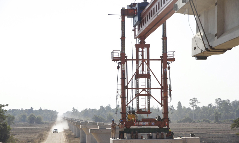 此次施工所需T梁從中國中鐵二局萬象制梁場發出，運輸需橫跨13號公路主路。為保證施工進度，萬象制梁場183名中國籍員工放棄春節休假，保證制梁場日均產量。圖為2月9日在老撾首都萬象拍攝的楠科內河特大橋架梁施工現場。新華社發（臧衡 攝）