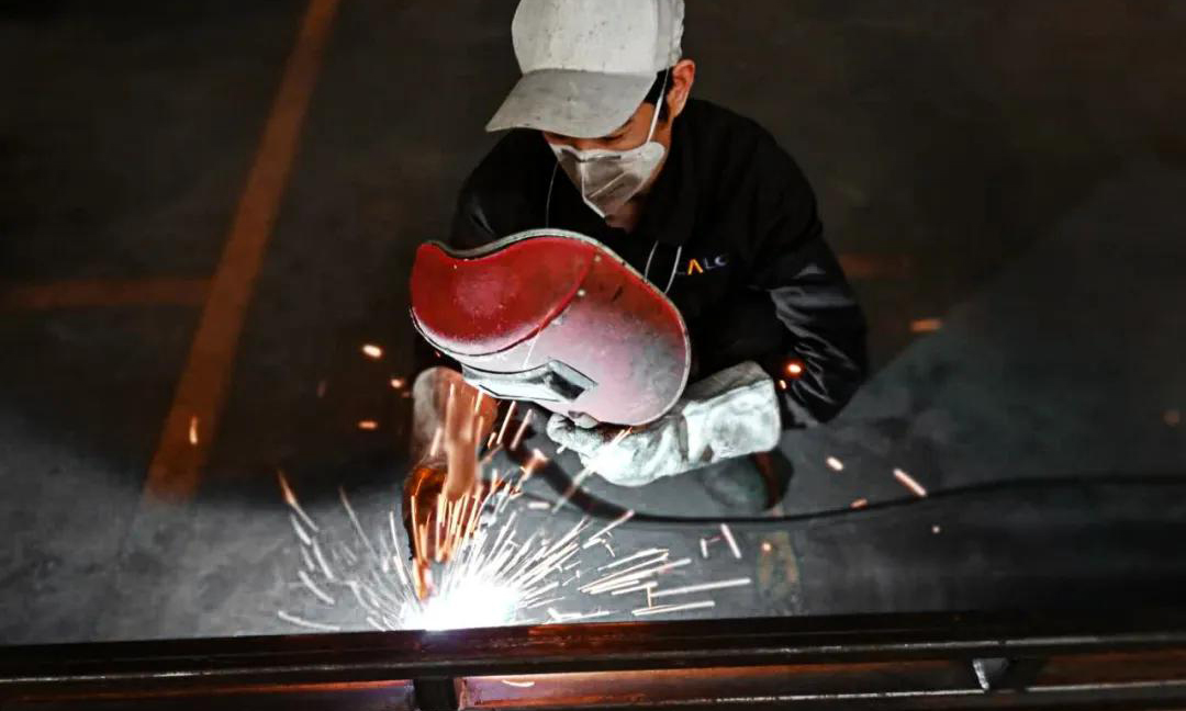  生產一線也是戰“疫”前線。長安民生物流長良包裝的員工正在焊接操作中，他們開足馬力，全力保供。