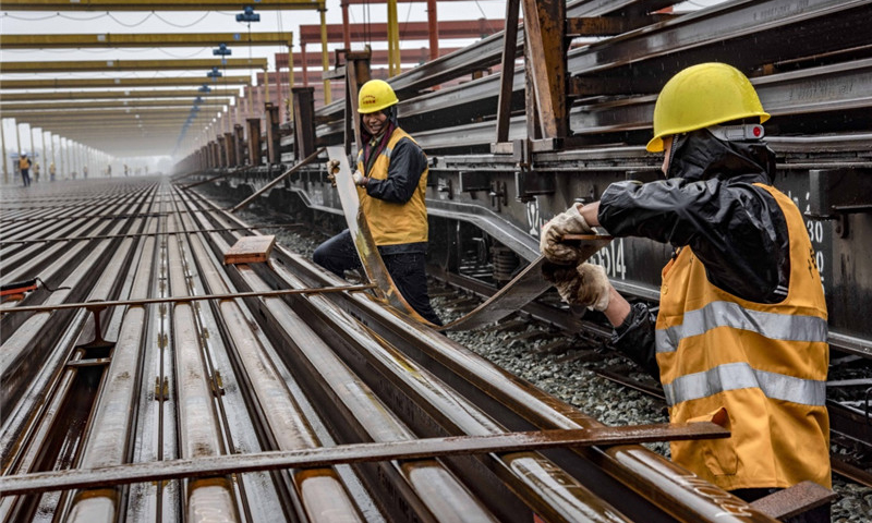 隨著漢十高鐵進入緊張的攻堅階段，承擔漢十高鐵全線鋪軌施工的中鐵十一局三公司已經全面展開長軌運輸、存儲、焊接等工作。目前，該公司漢十高鐵棗陽鋪軌基地已經存儲長軌262.5公里，為漢十高鐵全線長軌鋪設奠定了基礎。圖為5月5日，中鐵十一局職工在漢十高鐵棗陽鋪軌基地存軌區安放扁鐵，為堆碼500米長軌做準備。（新華社記者 杜華舉 攝）