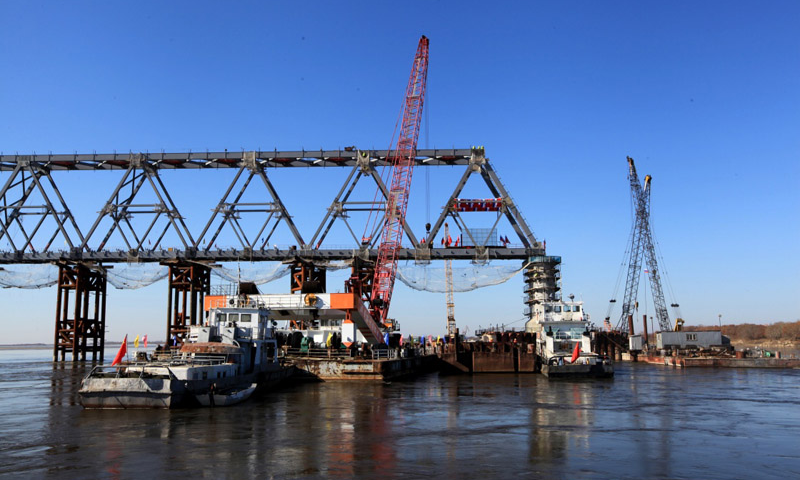 10月13日上午，中俄同江－下列寧斯闊耶鐵路橋重要組成部分——黑龍江特大橋中方最后一吊鋼梁安裝到位，標志著同江中俄鐵路大橋中方段主體工程全部完成。圖為10月13日拍攝的同江中俄鐵路大橋的中方建設部分。（新華社記者 馬知遙 攝）